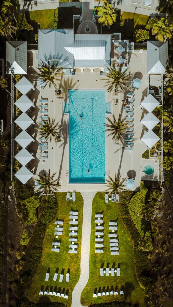 Aerial view of a resort pool surrounded by palm trees, resort for sale Langkawi Malaysia