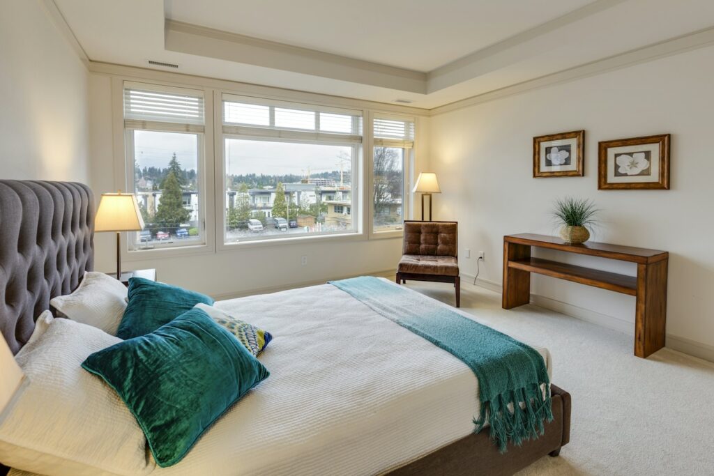 Main bedroom with made bed and soft lighting